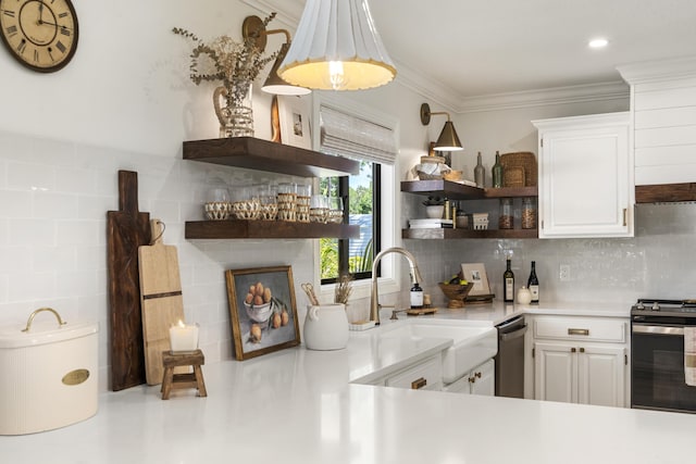 kitchen with sink, backsplash, white cabinets, and appliances with stainless steel finishes