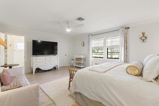 bedroom with ceiling fan, crown molding, and light hardwood / wood-style floors