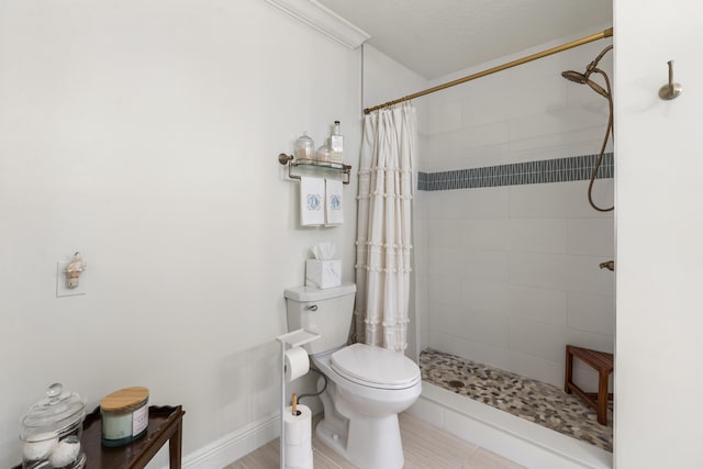 bathroom featuring toilet, tile patterned flooring, ornamental molding, and walk in shower