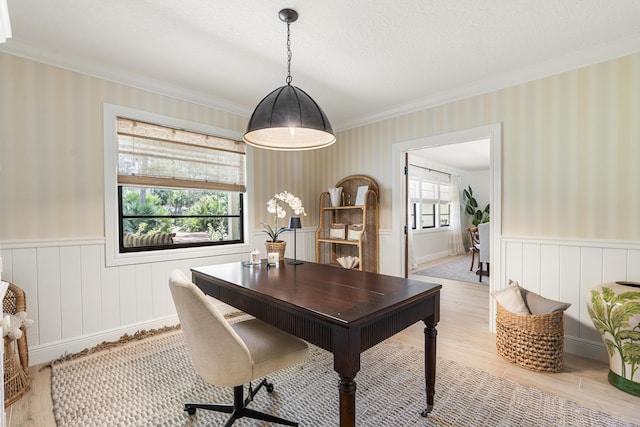 home office with light hardwood / wood-style floors, ornamental molding, and a textured ceiling