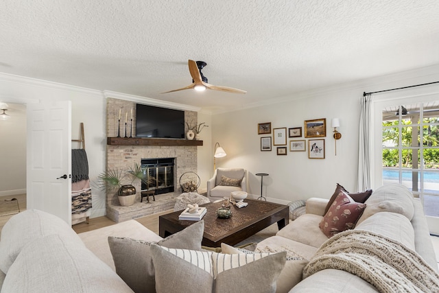 living room featuring light hardwood / wood-style floors, ceiling fan, a fireplace, a textured ceiling, and crown molding