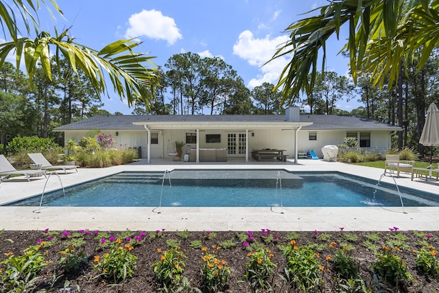 view of swimming pool featuring pool water feature, french doors, and a patio