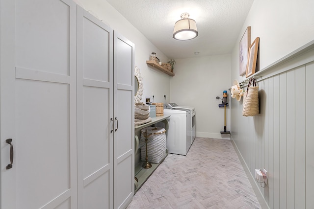 laundry area with a textured ceiling and washing machine and dryer