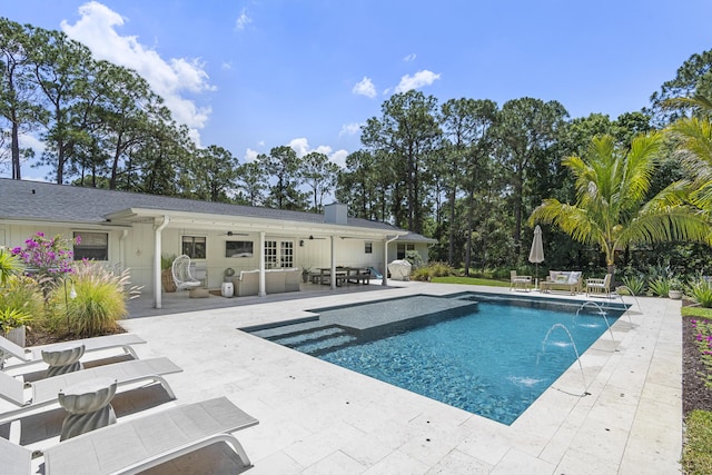 view of pool featuring pool water feature and a patio