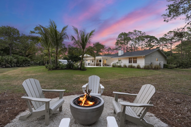 yard at dusk featuring an outdoor fire pit and a patio