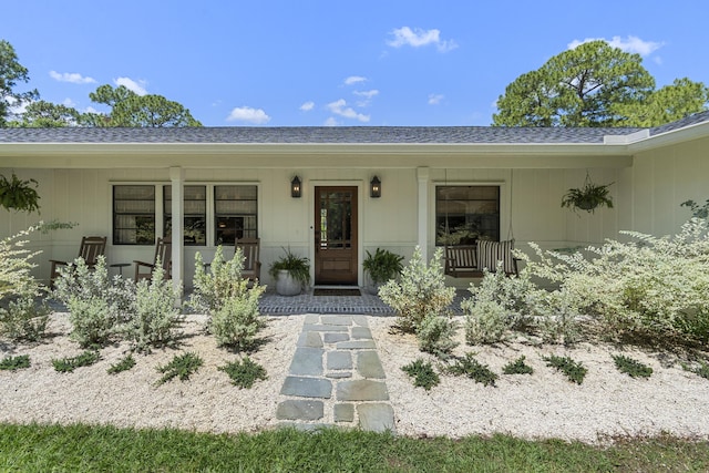 view of exterior entry featuring covered porch