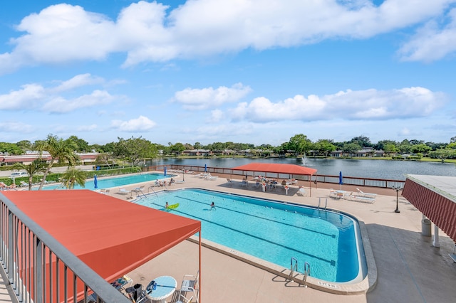 view of swimming pool featuring a patio area and a water view