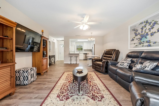 kitchen with stainless steel fridge with ice dispenser, light hardwood / wood-style flooring, kitchen peninsula, and backsplash