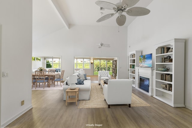 living room featuring hardwood / wood-style floors, ceiling fan, high vaulted ceiling, and beam ceiling