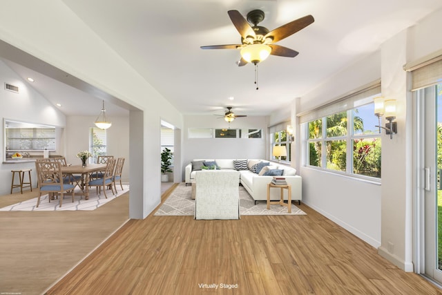 living room with light hardwood / wood-style flooring, ceiling fan, and plenty of natural light