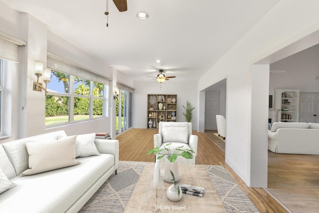 living room featuring wood-type flooring and ceiling fan