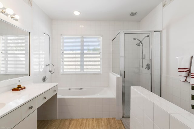 bathroom with shower with separate bathtub, wood-type flooring, and oversized vanity