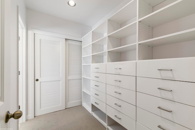 walk in closet featuring light colored carpet