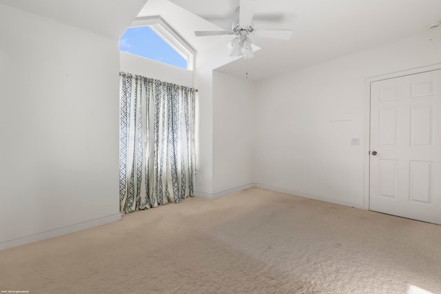 spare room featuring ceiling fan, vaulted ceiling, and carpet flooring