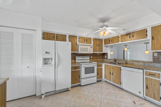 kitchen with hanging light fixtures, white appliances, sink, ceiling fan, and a textured ceiling