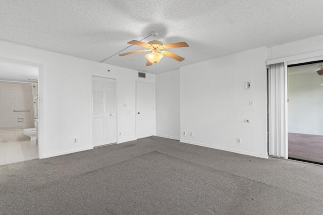 carpeted spare room with ceiling fan and a textured ceiling