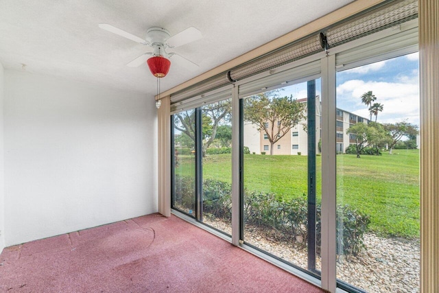 unfurnished sunroom featuring a healthy amount of sunlight and ceiling fan