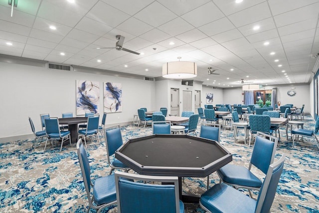 carpeted dining area with a drop ceiling and ceiling fan