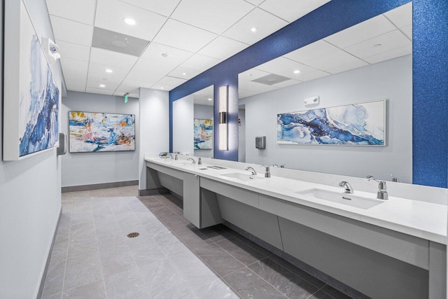 bathroom with tile flooring, dual sinks, oversized vanity, and a paneled ceiling