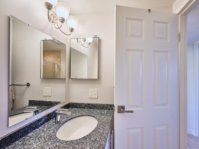 bathroom with a notable chandelier, vanity, and tile floors