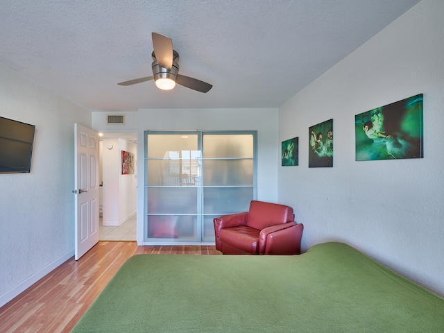 unfurnished room featuring hardwood / wood-style flooring, ceiling fan, and a textured ceiling