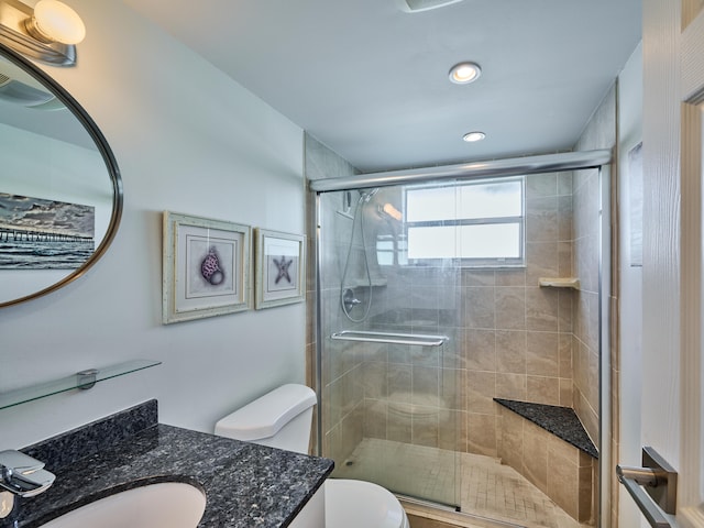 bathroom with walk in shower, toilet, and vanity