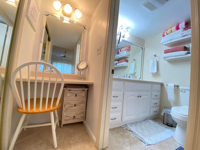 bathroom with tile patterned flooring, ceiling fan, toilet, and a textured ceiling