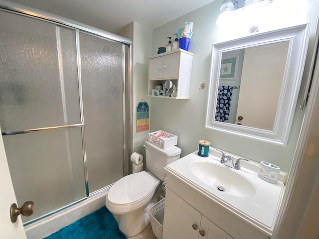 bathroom featuring toilet, vanity, and walk in shower