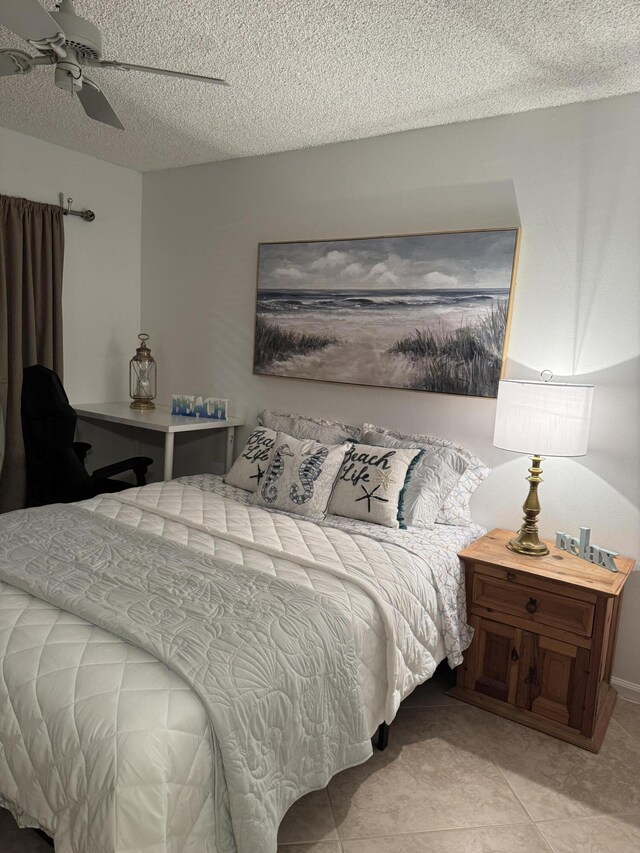 tiled bedroom featuring a textured ceiling and ceiling fan