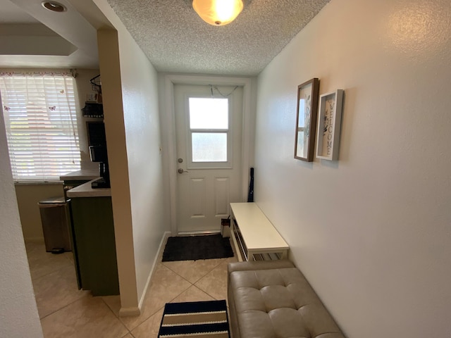 entryway featuring light tile patterned floors and a textured ceiling