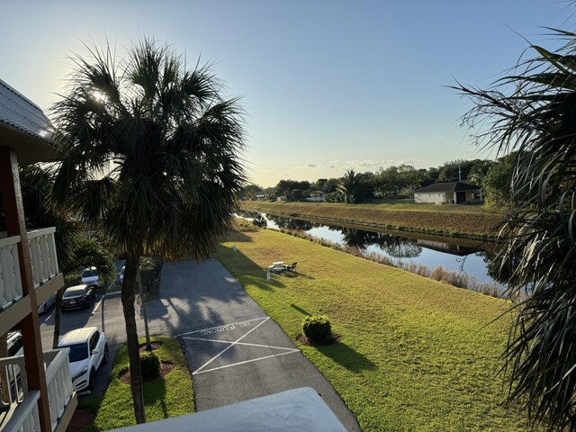 surrounding community featuring a lawn and a water view