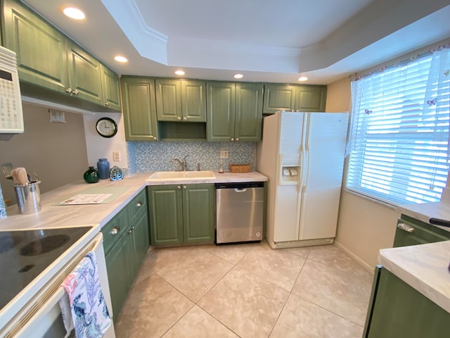 kitchen with dishwasher, white fridge with ice dispenser, sink, a raised ceiling, and green cabinets