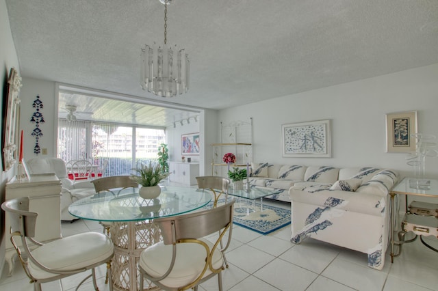 dining area with a chandelier, light tile floors, and a textured ceiling