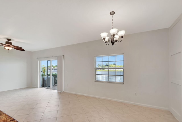 empty room featuring a healthy amount of sunlight, light tile floors, and ceiling fan with notable chandelier