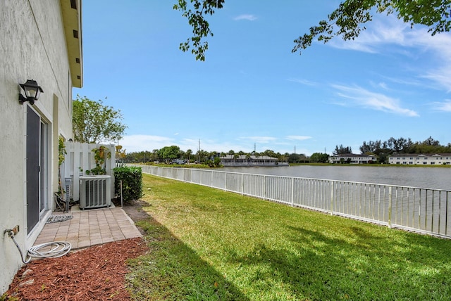 view of yard with a water view and central air condition unit