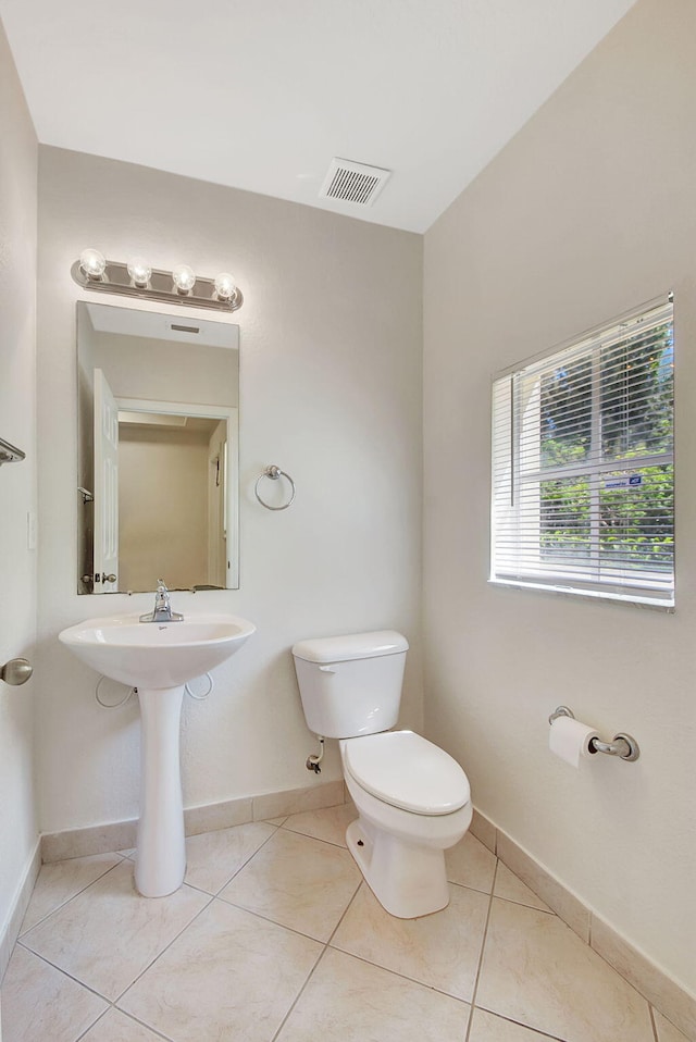 bathroom featuring toilet and tile floors