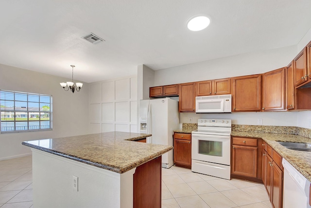 kitchen with white appliances, pendant lighting, light tile floors, and a chandelier