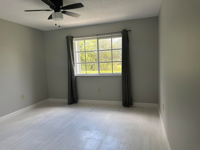 empty room featuring ceiling fan and a textured ceiling