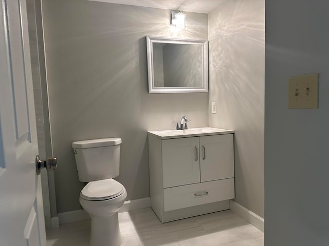 bathroom featuring wood-type flooring, vanity, and toilet