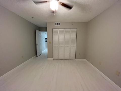 unfurnished bedroom with a closet, hardwood / wood-style floors, and ceiling fan