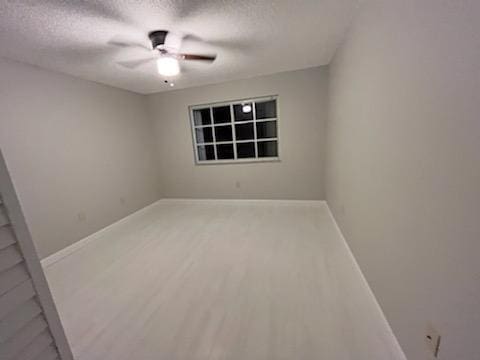 unfurnished room with wood-type flooring, ceiling fan, and a textured ceiling