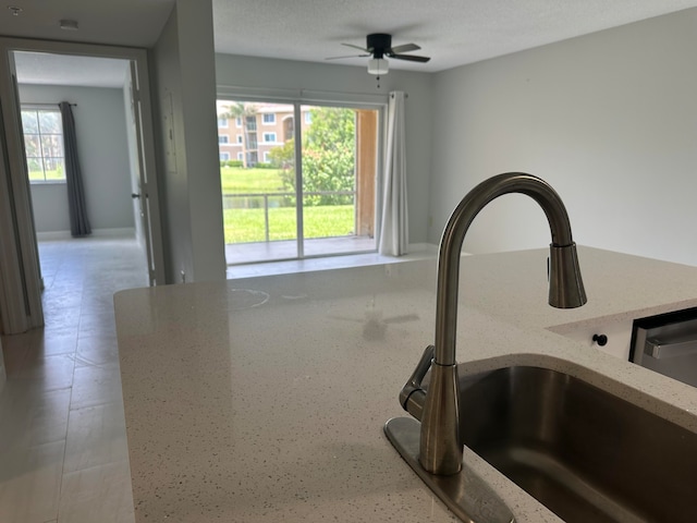 interior details with a textured ceiling, sink, and ceiling fan