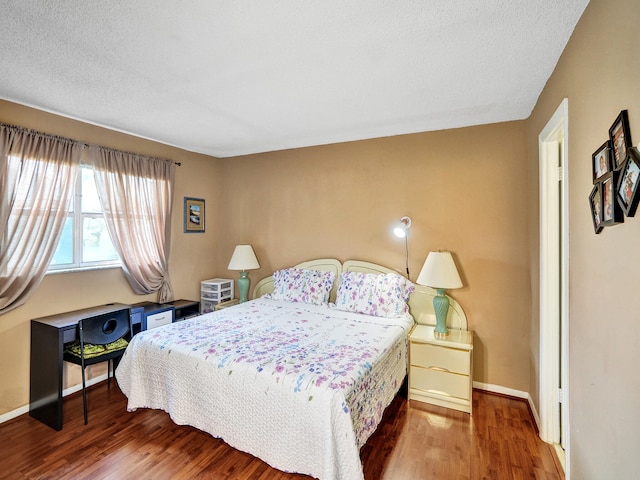 bedroom with hardwood / wood-style flooring and a textured ceiling