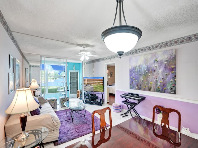 living room with a wall of windows, ceiling fan, and a textured ceiling