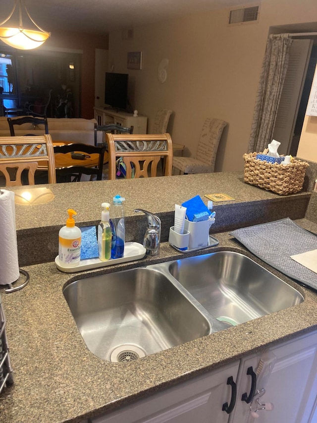 kitchen featuring white cabinets, sink, and stone counters