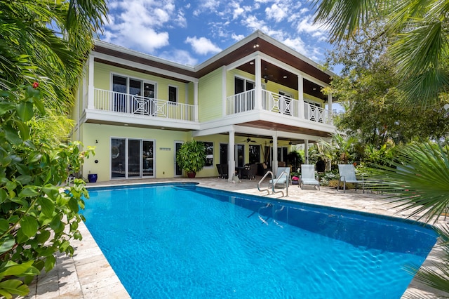 back of property featuring ceiling fan, a balcony, and a patio