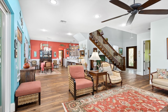 living room with wood-type flooring, ceiling fan with notable chandelier, and plenty of natural light