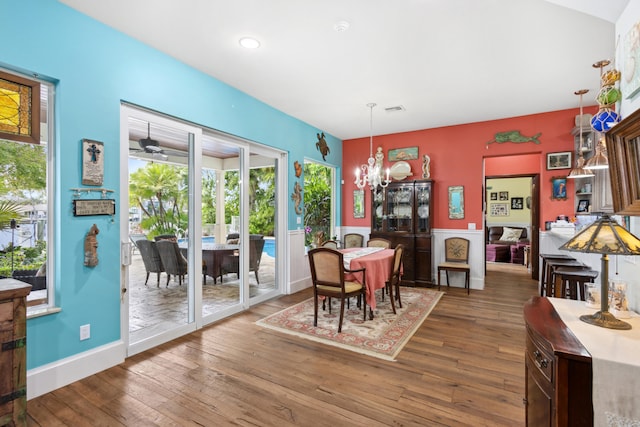 dining room featuring ceiling fan with notable chandelier and wood-type flooring