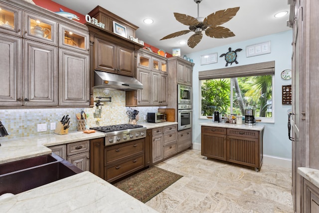 kitchen featuring dark brown cabinets, tasteful backsplash, appliances with stainless steel finishes, and ceiling fan