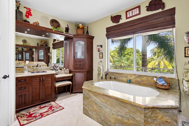 bathroom featuring tile patterned floors, vanity, and tiled bath